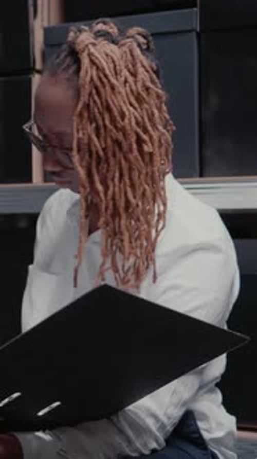 Serious Woman Works with Binder in Office