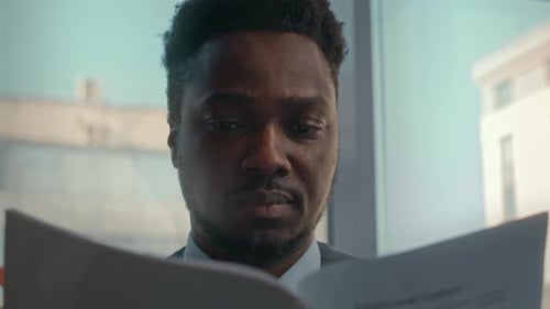 Black Man Reading Business Contract in Office