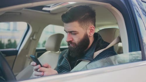 Close Up Face Smiling Young Handsome Happy Man Use Phone in the Car Look at Camera Driver Mobile