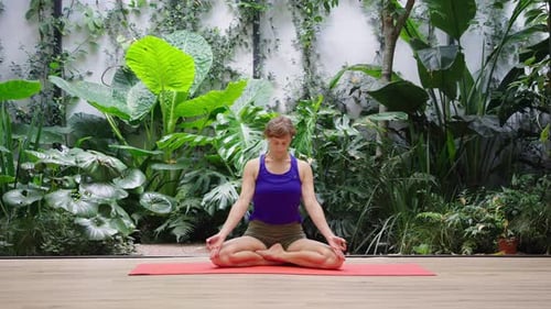 Woman Meditating in a Peaceful Indoor Garden Setting