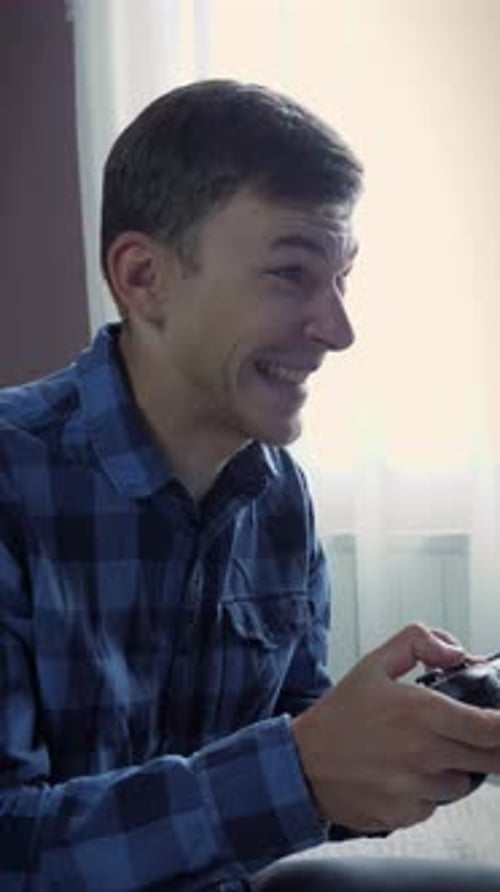 Excited Young Man Playing Video Game at Home