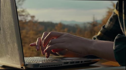 Reisender, Reisender Arbeitet aus der Ferne in den Bergen und schaut draußen in einen Laptop. Glatt