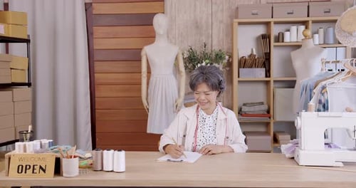 Senior Woman Fashion Designer Working in Studio