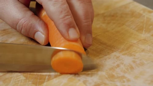 Slicing Carrot on a Cutting Board With Knife