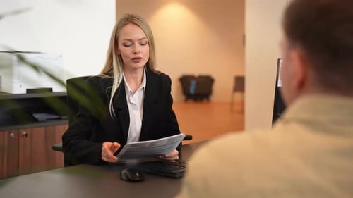 Woman Discussing Documents with Client in Modern Office