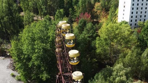 Abandoned Ferris Wheel in Overgrown Urban Landscape