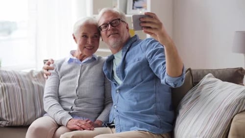 Happy Senior Couple Taking Selfie on Sofa