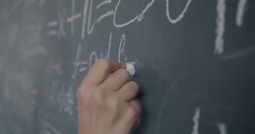 Closeup Slow Motion of Female Hand Teacher Writing Symbols on Chalkboard Teaching Physics in High