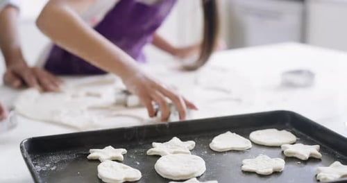 Child and Woman Baking Cookies Together in Kitchen