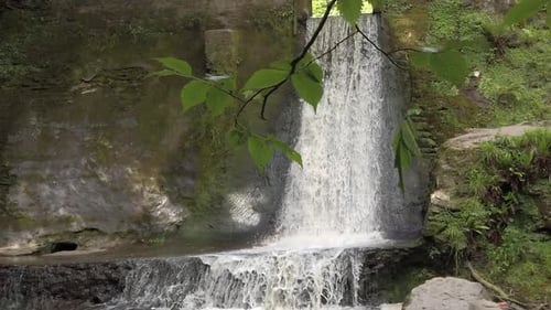 Peaceful woodland forest splashing waterfall slow motion flowing paradise wilderness dolly right und