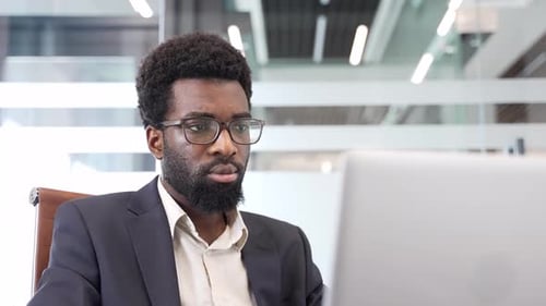 Man Works at Laptop in Modern Office