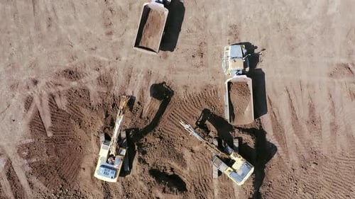 Excavators Loading Dump Trucks at Construction Site