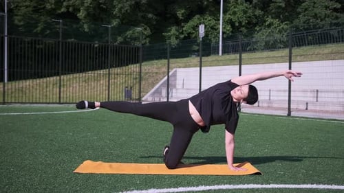 Woman Stretching Outdoors on Yellow Mat