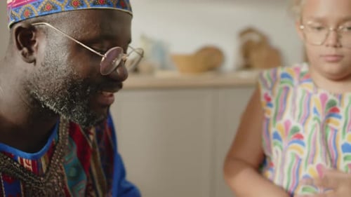 Man and Child Drumming on Djembe Indoors