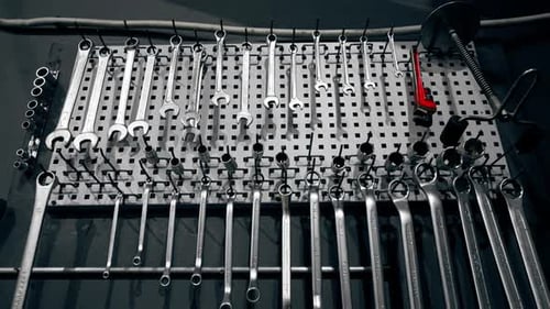 at the Service Station There is Board on the Wall with Wrenches and Other Tools Hanging on It