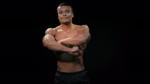 Shirtless Man Flexing Defined Muscles on Black Backdrop