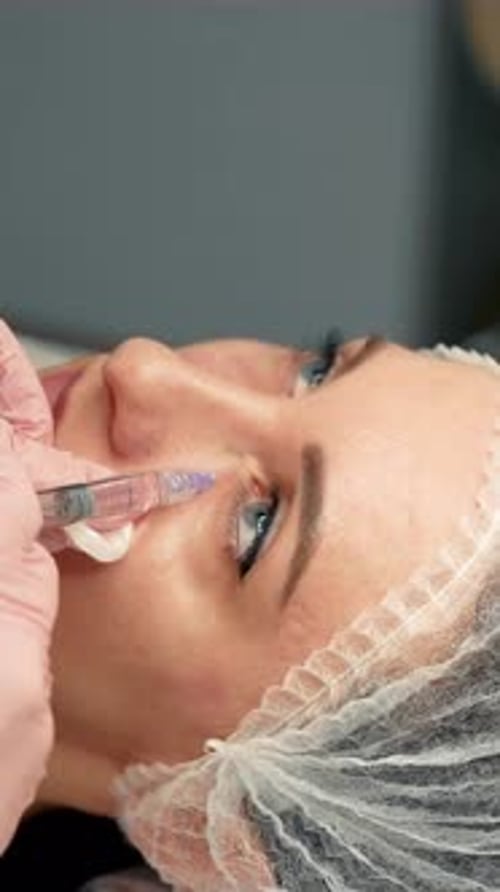 Woman Receiving Anti Aging Treatment From Doctor in Clinic Beautician Injecting Botulinum Toxin