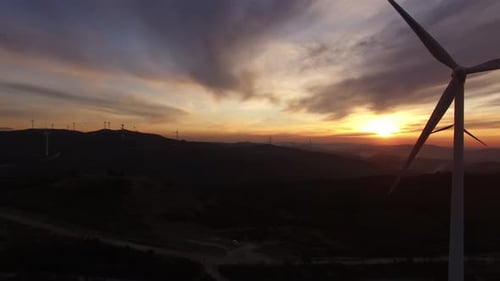 Windmills generating green energy by sunset