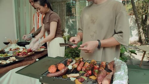 People Cooking Food On Outdoor Grill