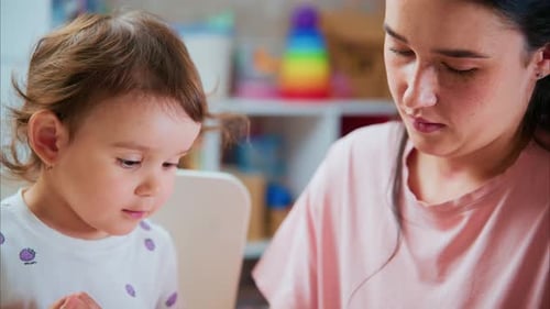 Girl and Woman Play with Modeling Clay Indoors