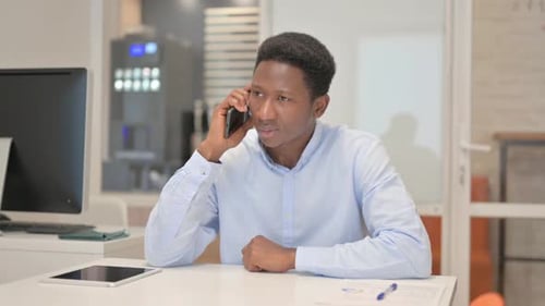 African Businessman Talking on phone in Office