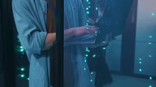 Workers Inspecting Servers with Laptop and Tablet