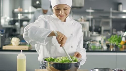 In a Famous Restaurant Female Cook Prepares Salad. She Works in a Big Modern Kitchen.