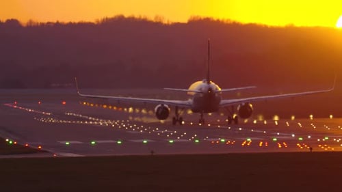 Passenger plane takes off into a vibrant sunset at the airport