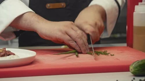 The Chef Deftly Prepares the Main Dish in the Restaurant Using a Keen Blade to Chop the Herbs