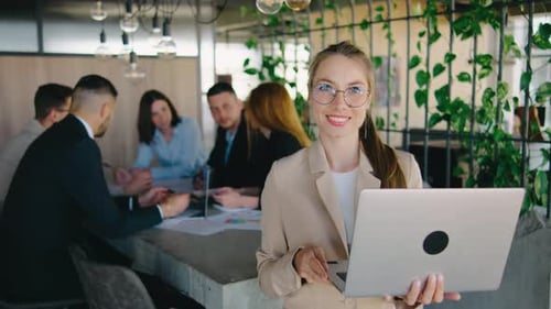 Woman Smiling With Laptop in Modern Office