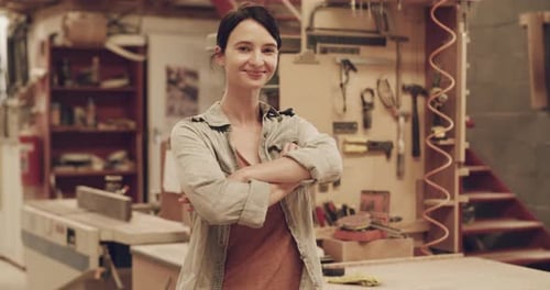 4k video footage of an attractive young female carpenter posing inside her carpentry workshop