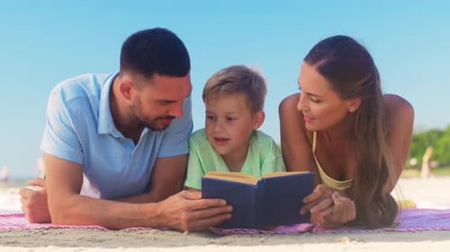 Happy family reading a book on the beach