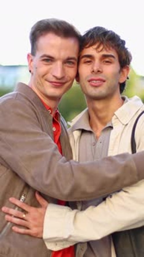 Happy Gay Couple Embracing and Smiling at Camera