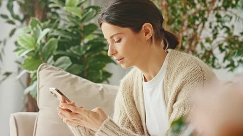 Woman Using Mobile Phone at Home