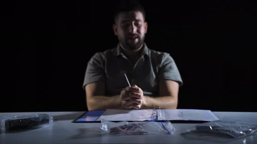 Man Under Interrogation at a Table