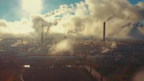 Power plant smokes. Aerial view of the power plant with smoking pipes and clouds passing by