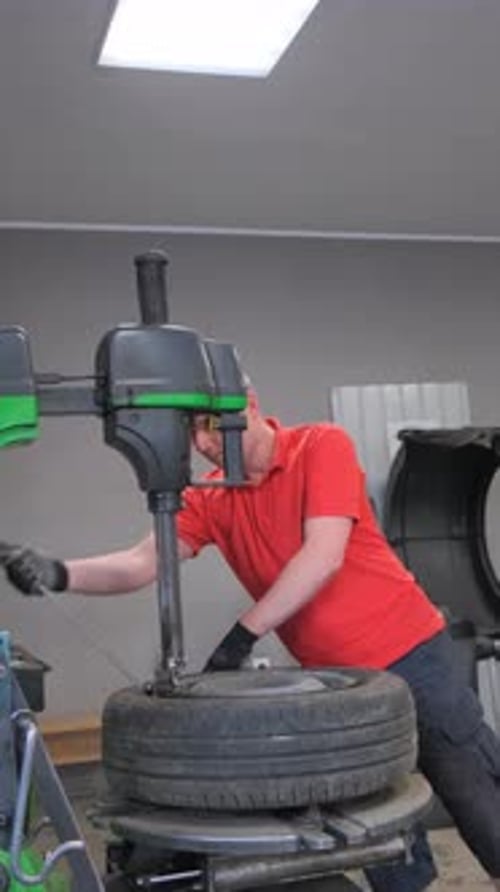 Porträt eines Mechanikers, der Autoräder repariert, Vertikales Video zum Autoservice