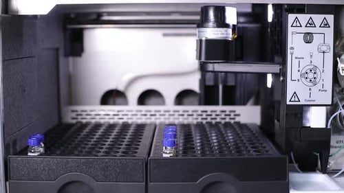 A bottle of vaccine filled by a robotic arm, it and puts it back. Vaccine making Vaccine filling