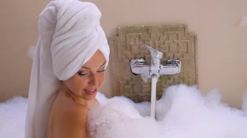 Sensual Woman Blowing Foam in Slow Motion with Bubbles in a Bathtub