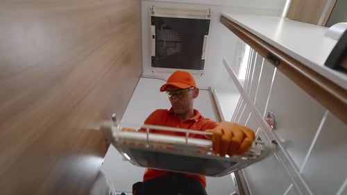 Man Removing Air Conditioner Filter for Cleaning