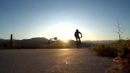 Biker riding on bike trail along the highway in slow motion