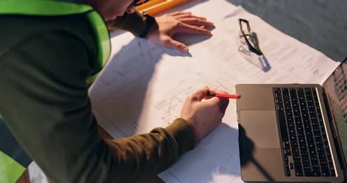 Person, hands or architect with blueprint or laptop on construction site for building or planning