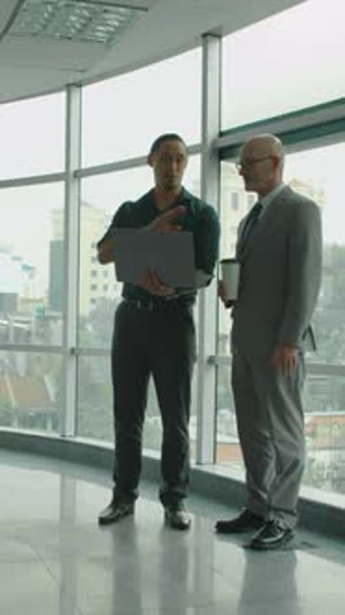 Businessmen Discussing Work in Modern Urban Office