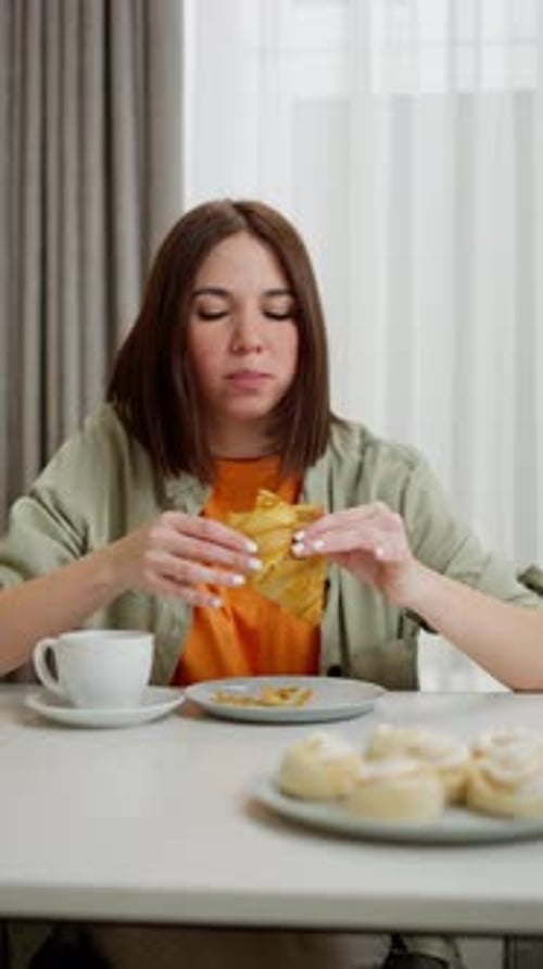 Vertical Video A Brunette Woman with a Bob Hairstyle in an Orange Shirt and a Light Green Jacket