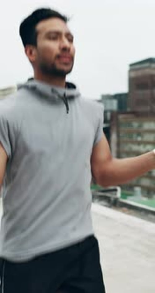 Asian man, fitness and jumping rope on rooftop in city for workout, cardio exercise