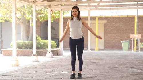 Young Woman Doing Arm Stretches in Urban Setting
