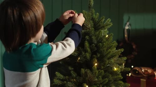 Child Decorates a Small Christmas Tree
