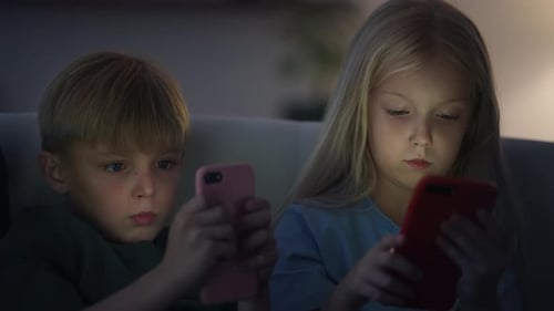 Blonde Children Using Cell Phones at Night