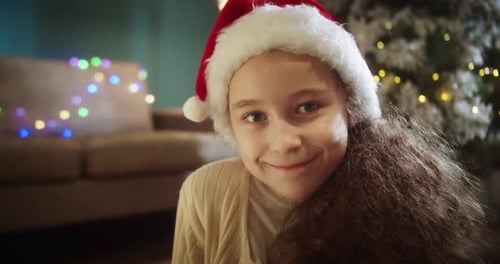 Smiling Girl in Santa Hat at Christmas