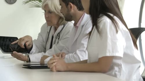 Medical Team Discussing Patient X-ray in Office